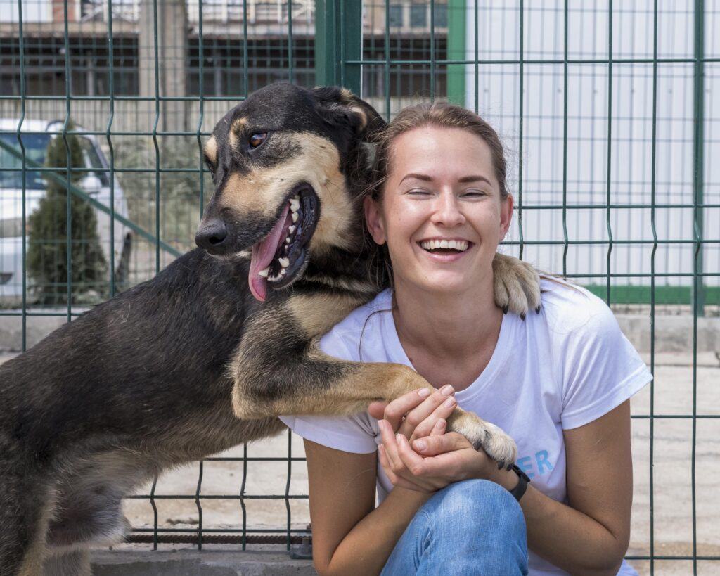 smiley woman playing shelter with dog waiting be adopted